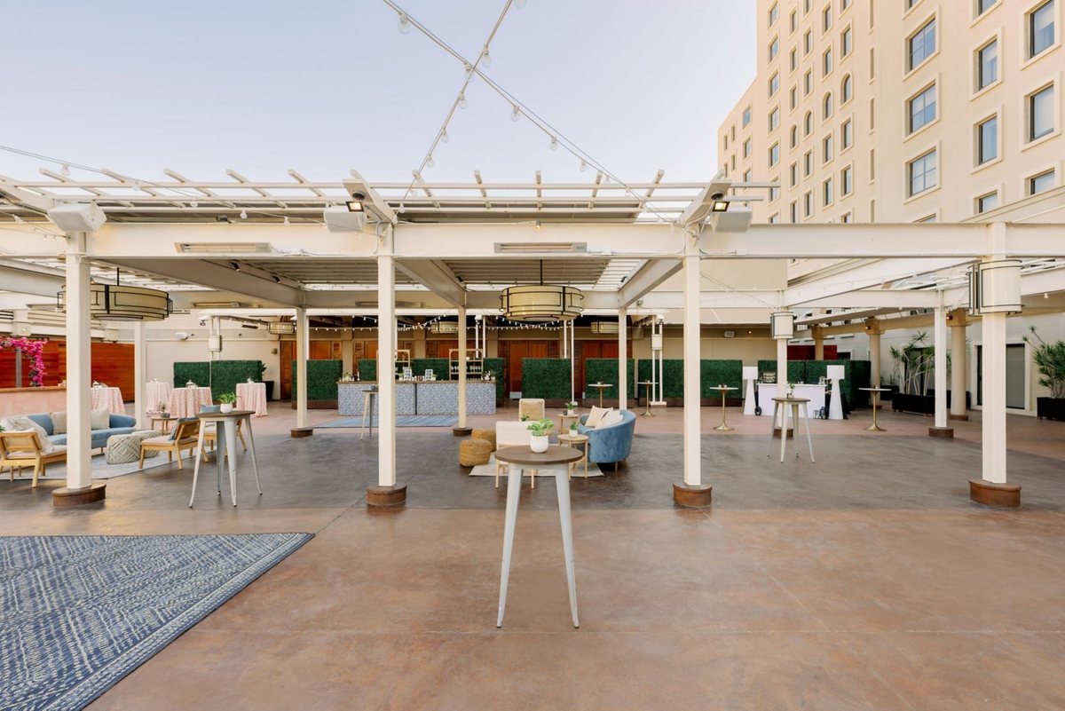 The covered Garden Terrace with white pergolas and lounge seating