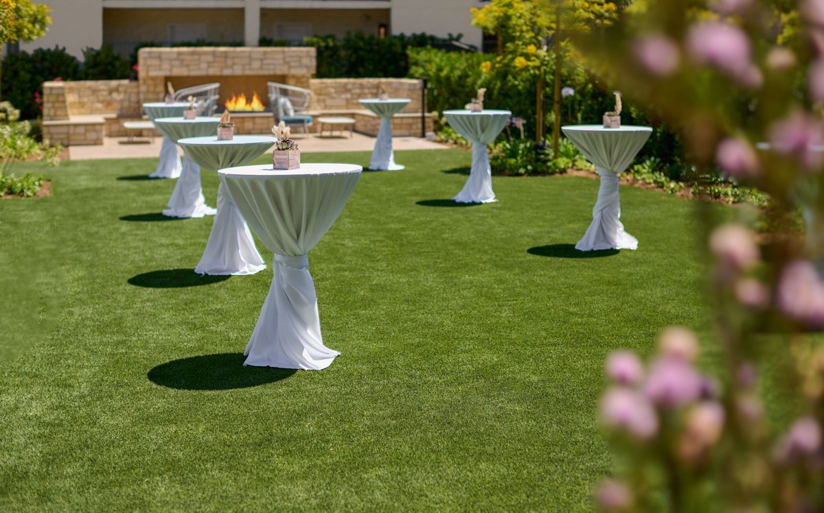 Spa Lawn set for a cocktail reception with high-top tables and a fire feature