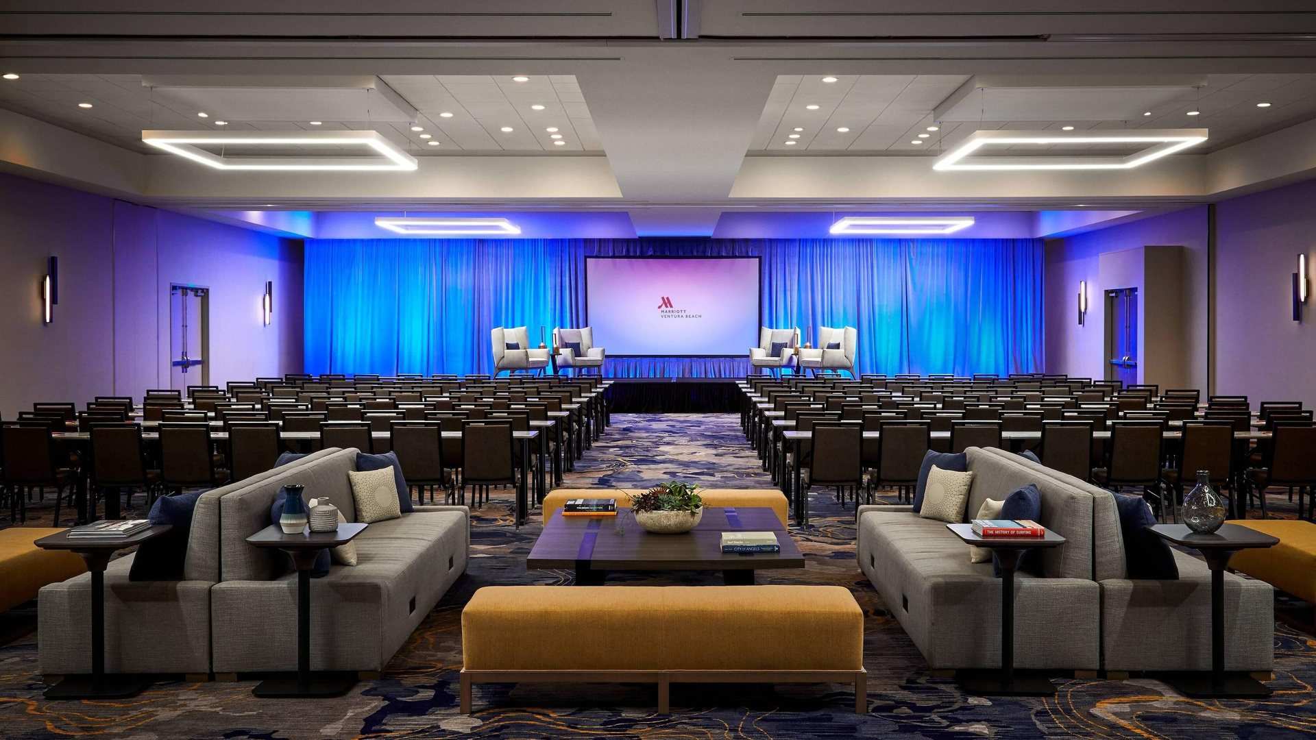 The San Buenaventura Ballroom at Ventura Beach Marriott set theater style facing a stage with screens and blue lighting